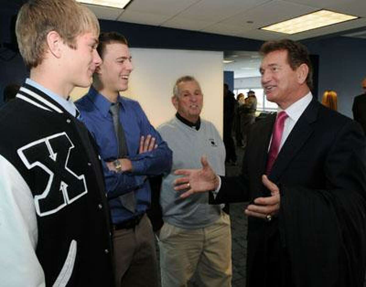 Former Washington Redskins quarterback Joe Theismann right spoke to the student athletes attending the CIAC luncheon at Rentschler Field East Hartford including Xavier's Tim Boyler of Middlefield left and Pat D'Amato of Wethersfield second from left and their coach Dick Nobile. Photo by Mara Lavitt/New Haven Register12/6/10