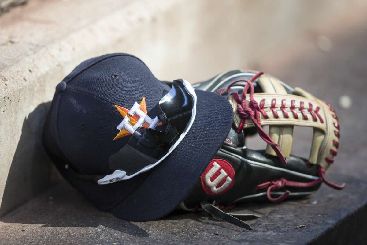 A Houston Astros baseball hat and Wilson glove on the steps of the dugout during a game between the Houston Astros and Seattle Mariners at Safeco Field on June 25, 2017 in Seattle, Washington.