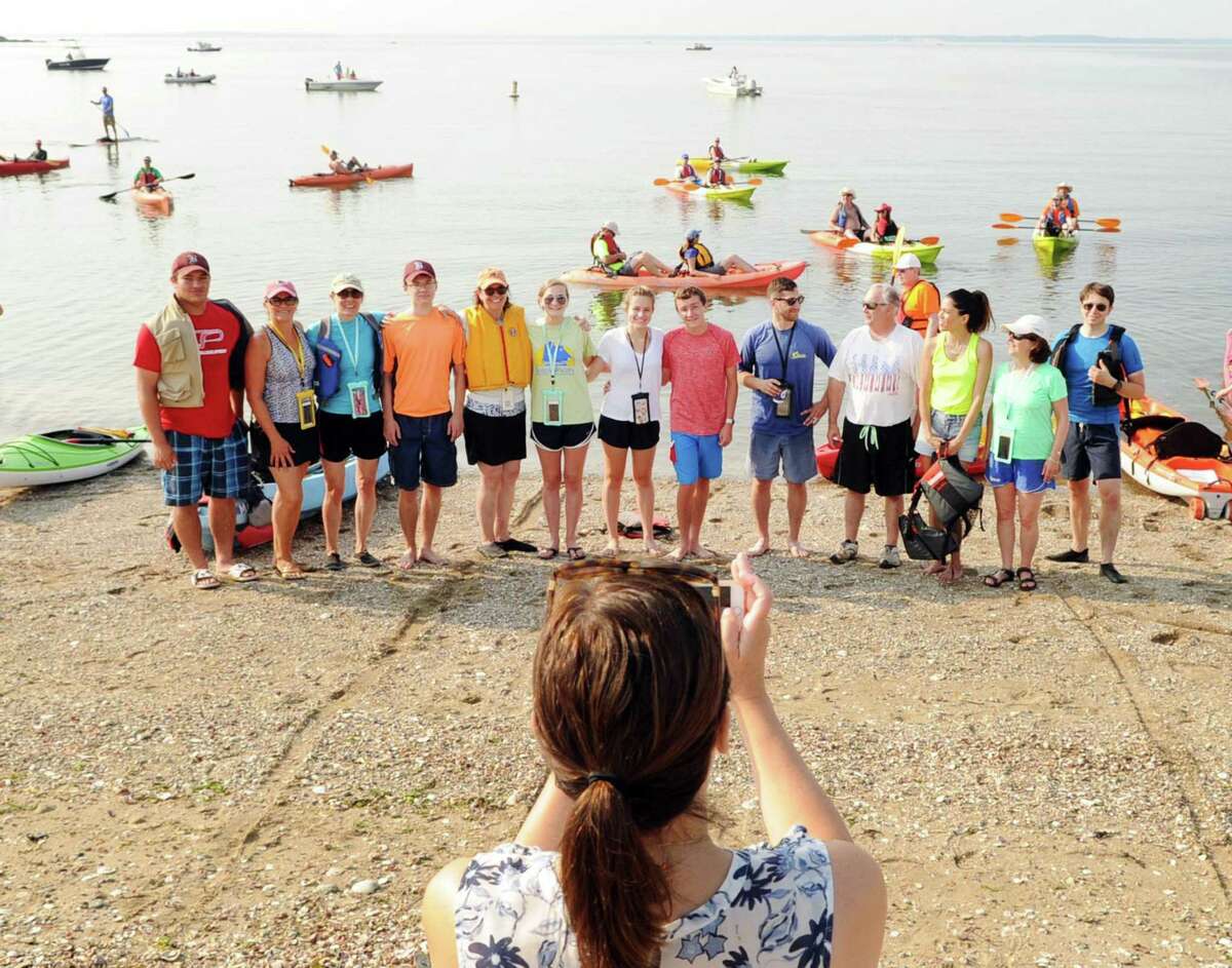 The Holly Pond Paddlers of Darien have a group photo taken during the SoundWaters Flotilla Fundraising Event to protect Long Island Sound, a kayak and paddle board event that started from Cove Island Park in Stamford Saturday morning, July 22.