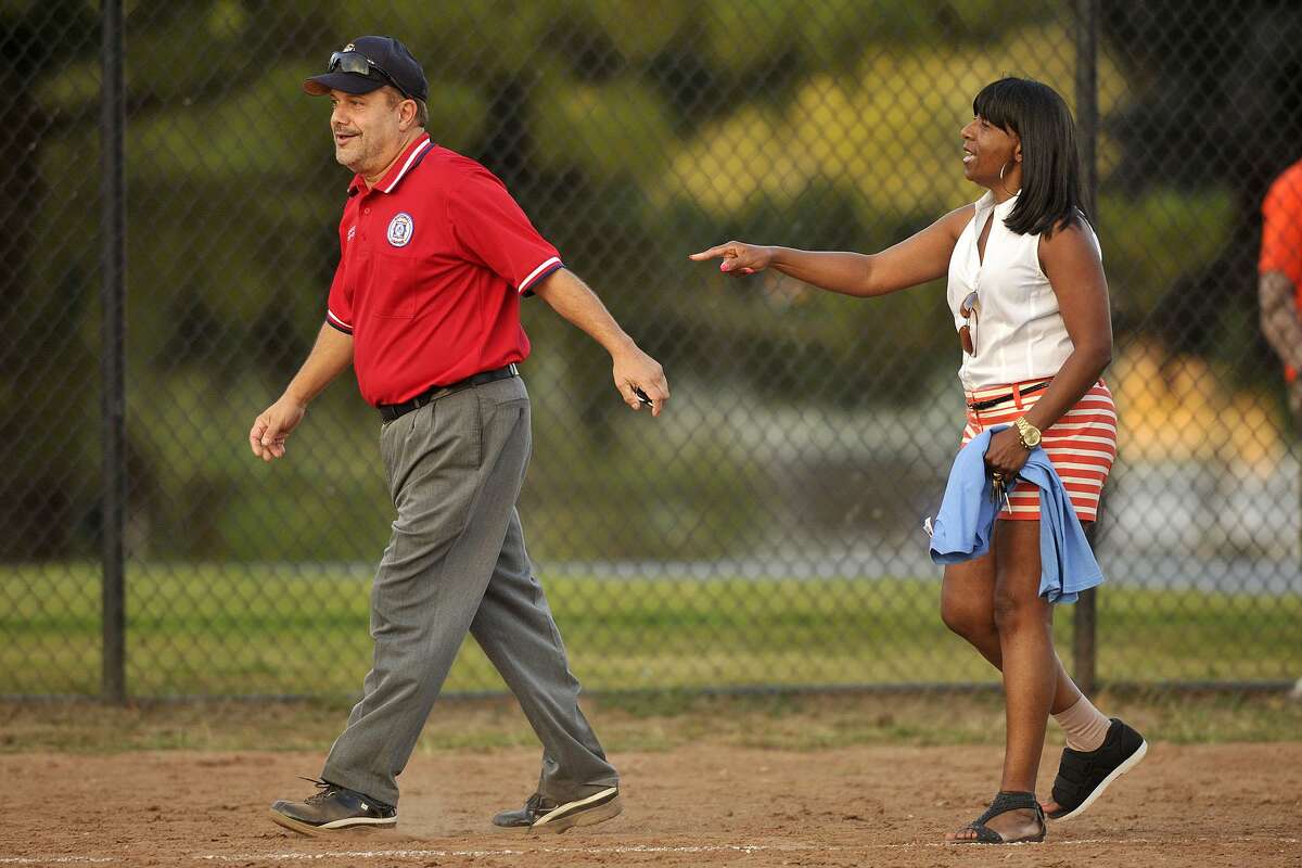 FILE — Board of Reps' third base coach Gloria DePina argues with umpire Charles Pia during the 31st annual Mayor's Team versus Board of Reps' Team softball game at Boccuzzi Park in Stamford, Conn., on Thursday, Aug. 28, 2014.