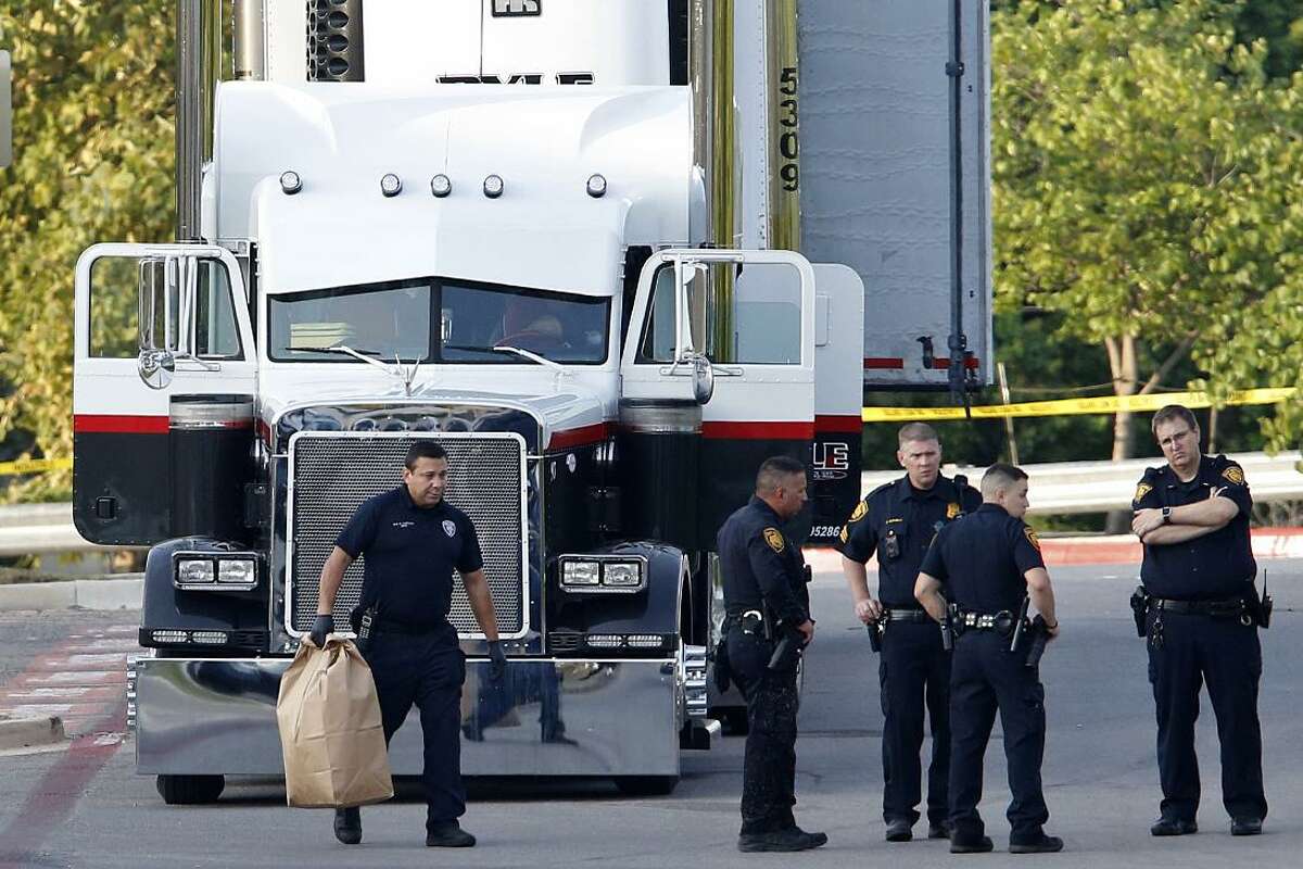 Law enforcement survey the scene, where people were discovered inside a tractor trailer in a Walmart parking lot at IH35 South and Palo Alto Road, July 23, 2017. The harrowing trip resulted in 10 dead and many more in critical condition.