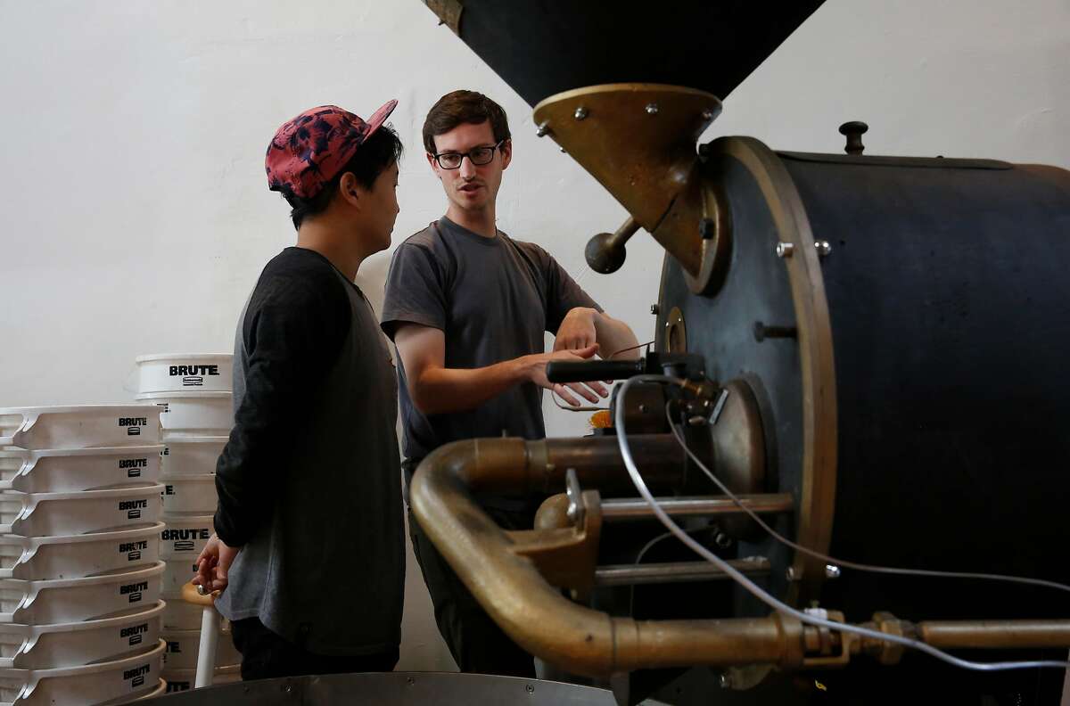 Roasting Facility Manager John Felder, right, teaches Barista and Roaster in Training Joshua Lee how to use the company's vintage German-made coffee roaster at Saint Frank coffee on Mission Street in San Francisco.