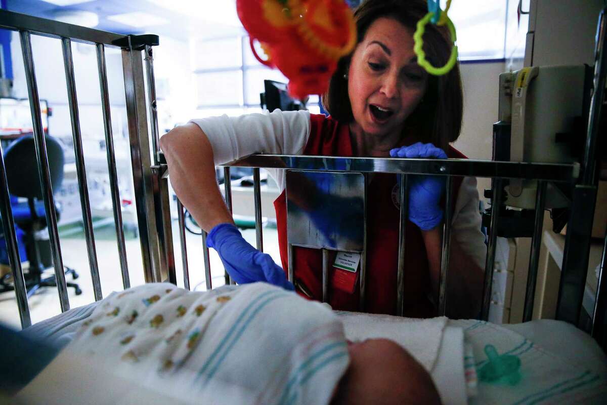 Volunteer Nancy Baycroft comforts 3-month-old Walter Omar Pineda-Real in the neonatal intensive care unit.