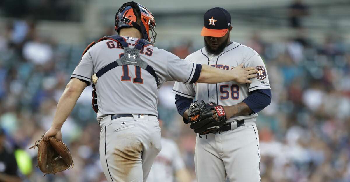 Houston Astros catcher Evan Gattis (11) talks with relief pitcher Francis Martes (58) during the seventh inning of a baseball game against the Detroit Tigers, Saturday, July 29, 2017, in Detroit. (AP Photo/Carlos Osorio)