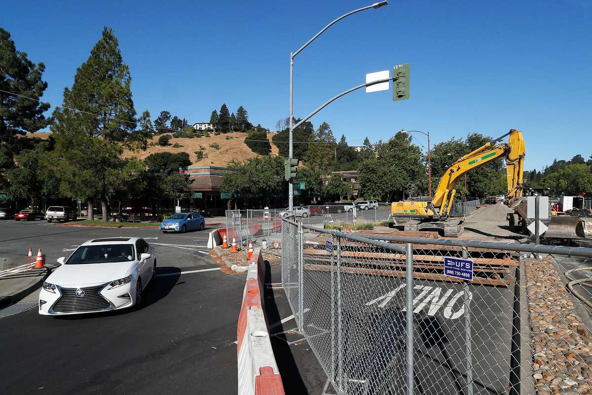 Vehicles pass by as repairs crews continue to fix the giant sinkhole at the corner of Rheem Blvd. and Moraga Rd. on Fri. July 28, 2017 in Moraga, Ca.