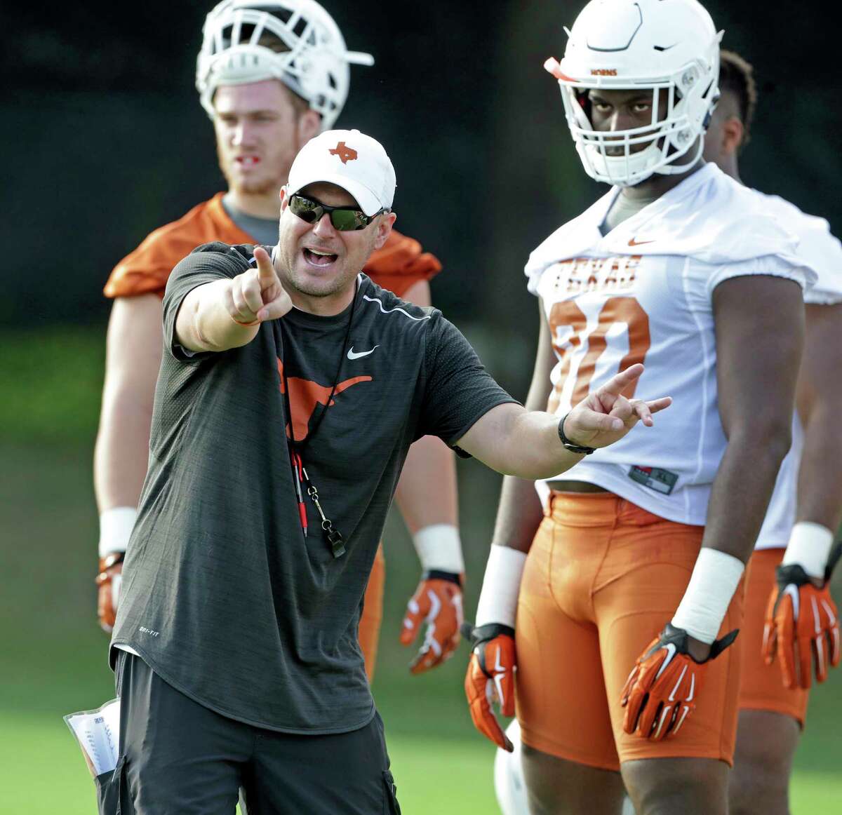 Coach Tom Herman spends time with linemen as the Longhorns begin their fall football practice at Frank Denius Fields at the University of Texas on July 31, 2017.