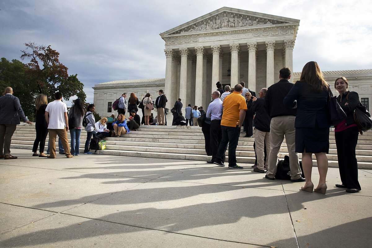FILE - In this Tuesday, Oct. 13, 2015 file photo, people line up outside of the Supreme Court in Washington as the justices began to discuss sentences for juvenile prison 'lifers.' In the Monday, Jan. 25, 2016 decision for Montgomery v. Louisiana, the court ruled that people serving mandatory life-without-parole terms for murders they committed as teenagers must have a chance to seek their freedom. The plaintiff, Henry Montgomery, recently learned he will get a chance at parole, 54 years after the killing. (AP Photo/Jacquelyn Martin, File)