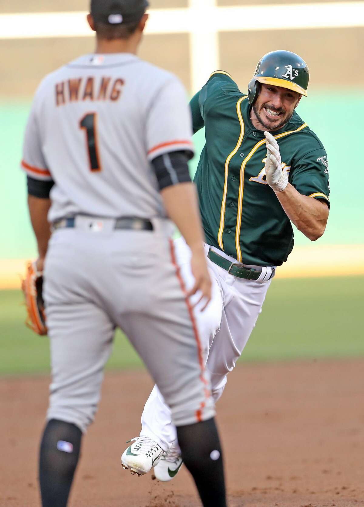 Oakland Athletics' Matt Joyce heads for third base while scoring on Jed Lowrie's RBI single in 1st inning against San Francisco Giants during MLB game at Oakland Coliseum in Oakland, Calif. on Monday, July 31, 2017.