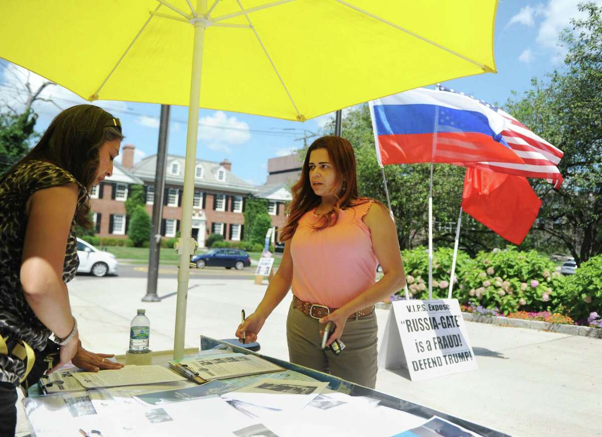 Sylvia Rosas, left, of Hackensack, N.J., talks politics with Greenwich resident Carla Gooley outside Town Hall in Greenwich, Conn. Tuesday, Aug. 1, 2017. Greenwich resident Patrick Servidio organized a stand to voice his opinions defending President Trump and hand out information from the Lyndon LaRouche PAC.
