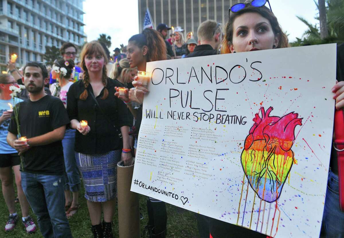 Macaila Fernandes, of Orlando, Fla. holds a poster as she joins a candlelight vigil at Lake Eola Park in Orlando, Fla. on June 19, 2016.