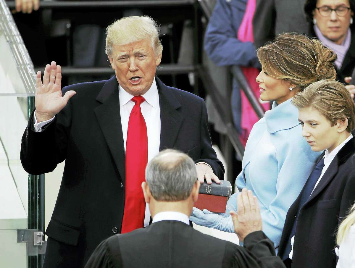 Donald Trump is sworn in as the 45th president of the United States by Chief Justice John Roberts as Melania Trump looks on during the 58th Presidential Inauguration at the U.S. Capitol in Washington, Friday, Jan. 20, 2017.