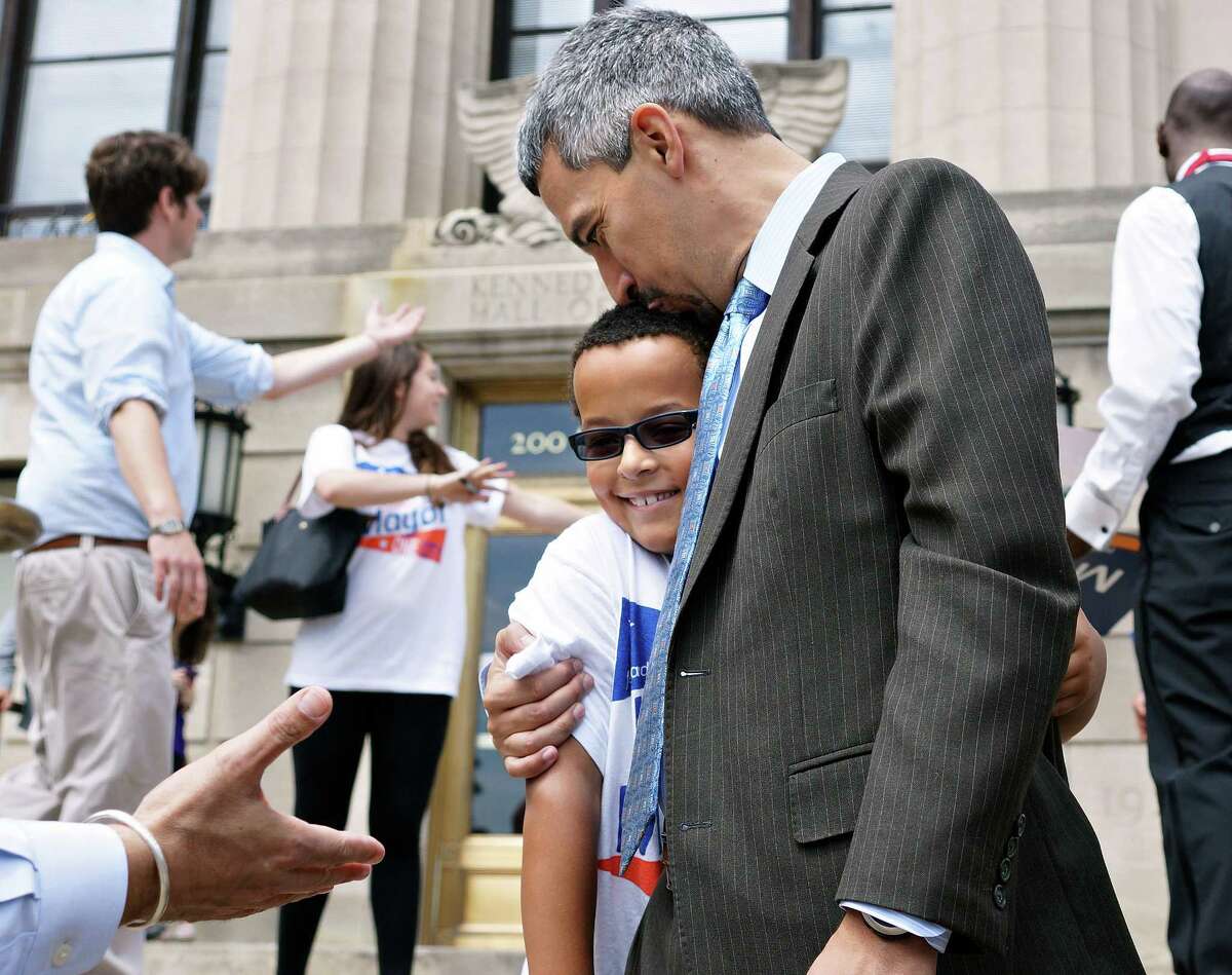 Peter Casolino — Register Mayoral candidate Henry Fernandez hugs his son, Henry Fernandez lV, 8, outside the Hall of Records after dropping off signatures on petitions to be included on the primary ballot. pcasolino@newhavenregister.com