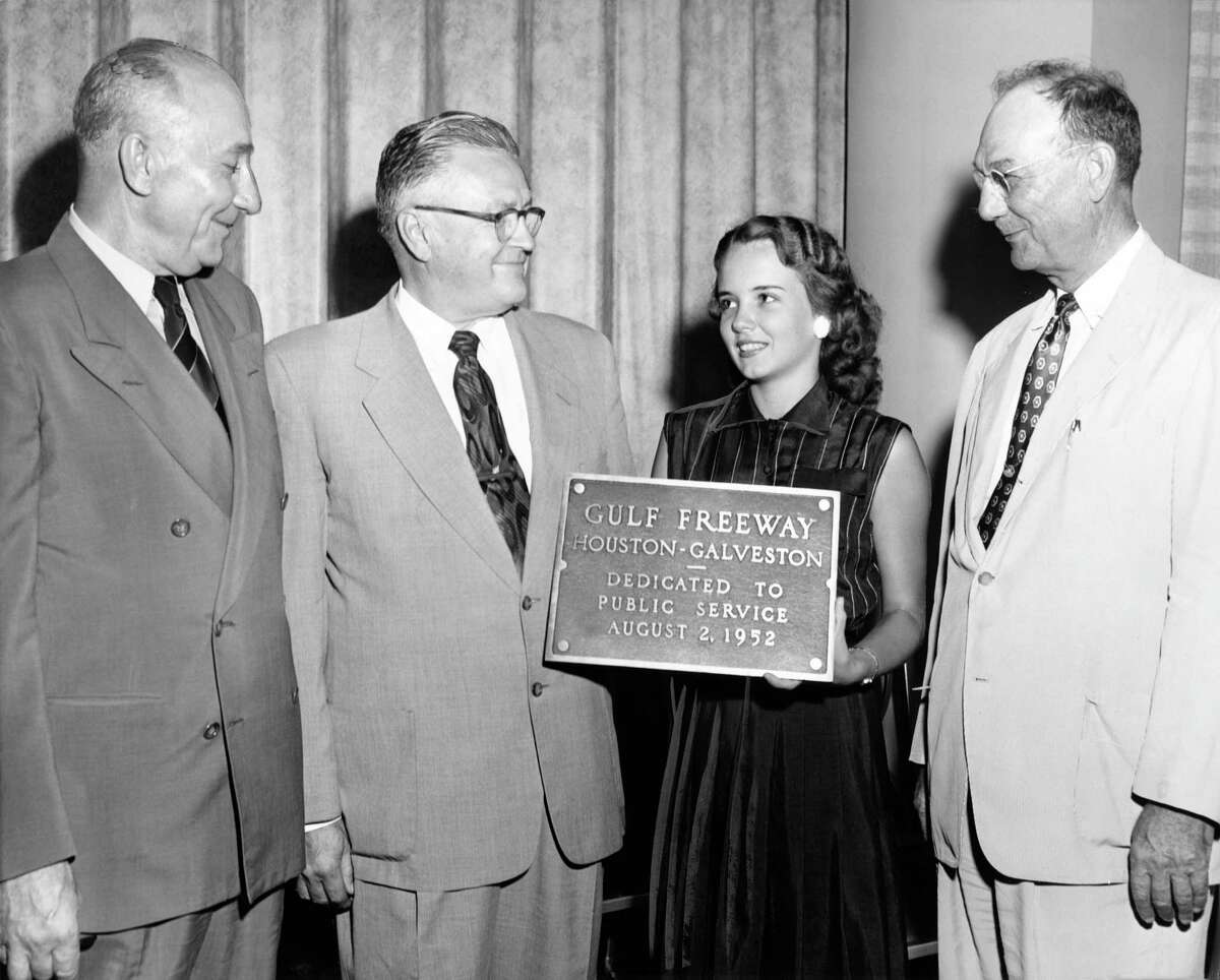 07/22/1952 - To public service, so reads the bronze plaque to be placed into position marking end of construction of the Gulf Freeway August 2. Plans for opening day ceremonies were disclosed at a press conference Tuesday held at the Houston Club. At the press conference were (L-R) urban engineer W.J. Van London; Madison Farnsworth, chairman of the dedication committee; Mary Jane Walton, Miss Houston; and District Highway Engineer Jim Douglas. The 50.75 mile freeway willl be opened to through traffic from Galveston to Houston immediately following the dedication ceremonies.