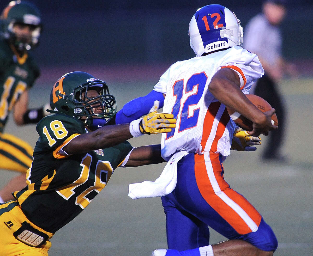 (Peter Casolino — New Haven Register) Hamden's Trevor Perry gets a handle on Danbury's Anferny Ith in the first quarter.