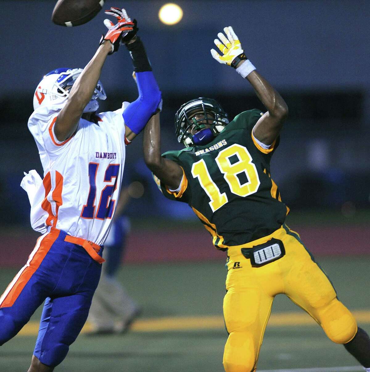 (Peter Casolino — New Haven Register) Danbury's Anferny Ith breaks up a pass intended for Hamden's Trevor Perry in the first quarter.