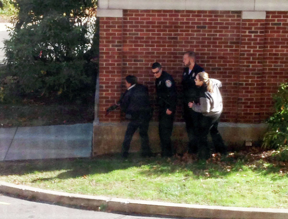 In this photo taken through a window and provided to the AP, which has been authenticated based on its contents and other AP reporting, police officers respond to a report of a suspicious person at Central Connecticut State University in New Britain, Conn., Monday, Nov. 4, 2013, The campus was locked down Monday and students were urged to remain indoors and away from windows. (AP Photo/Kiara Gupton via WFSB)