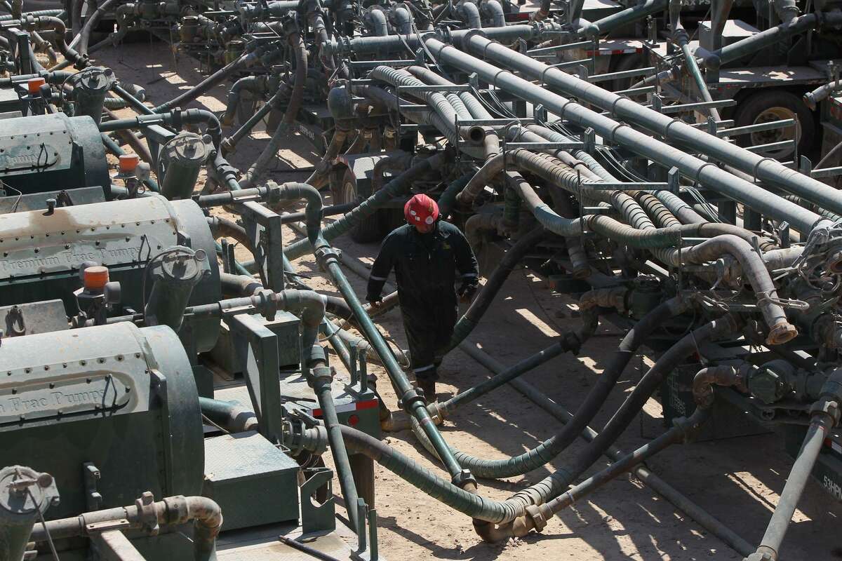 An oil worker walks pass the manifold (right) and frac pumps (left) at a Chesapeake Energy hydraulic fracturing operation near Carrizo Springs, Texas Thursday May 5, 2011. Hydraulic fracturing is a method of removing oil and gas from rock formations such as the Eagle Ford shale formation in south central Texas. JOHN DAVENPORT/jdavenport@express-news.net