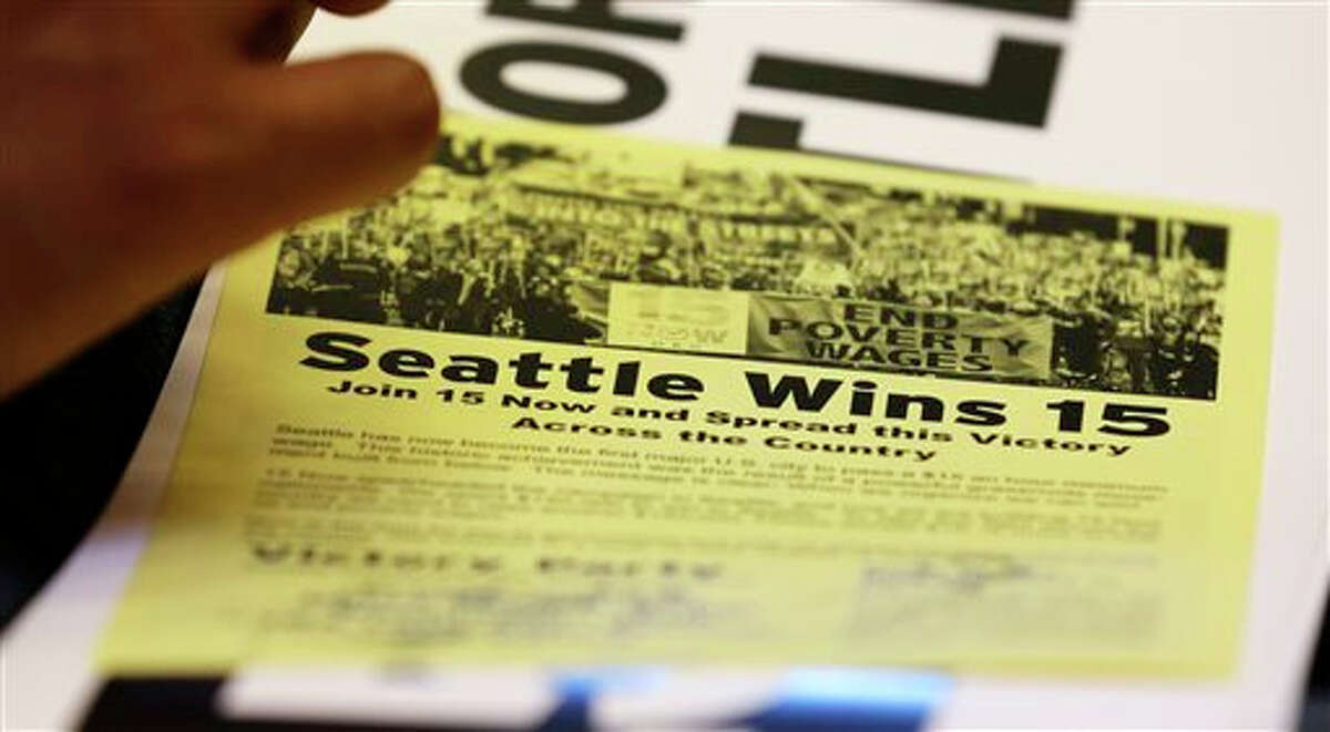 A flyer celebrating the passage of a $15 minimum wage law by the Seattle City Council is photographed Monday, June 2, 2014, during a meeting of the Seattle City Council, where the measure was passed.