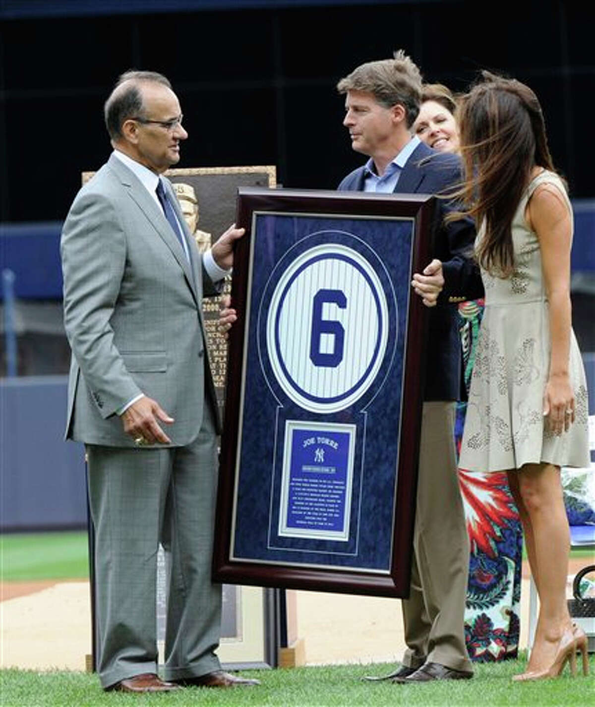 New York Yankees owner Hal Steinbrenner presents Joe Torre, right, with a plaque of his retired number before a baseball game against the Chicago White Sox Saturday, Aug. 23, 2014, at Yankee Stadium in New York.