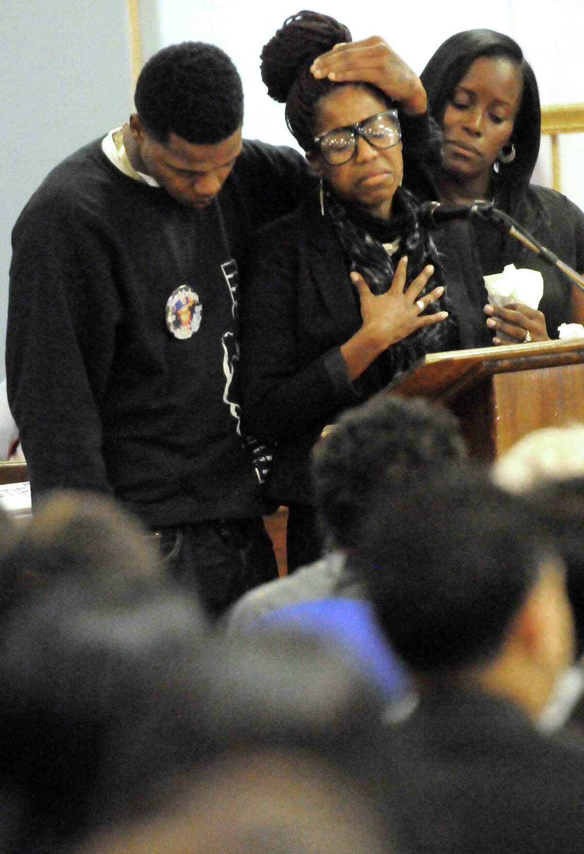 (Peter Hvizdak — Register) Gregory Fulcher, Jr.of West Haven, left, comforts Lakeisha Robinson of East Haven, center, as Robinson speaks at the funeral of her sister Erika Renee Robinson Saturday November 2, 2013 at the Agape Christian Center in New Haven, Conn. Robinson was the unintended victim of a shooting last week at the Key Club in New Haven, Conn.