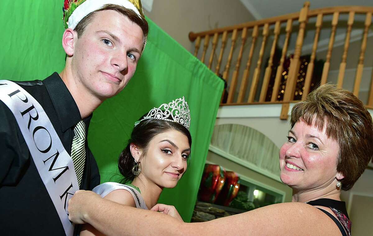 Principal Pam Gardner tweaks Prom Queen, Joey Pascale and Prom King, Kevin McDaniel before their photographed by master portrait photographer Sue Drew at the West Haven High School senior prom, Friday, May 22, 2015 at Fantasia in North Haven, Conn. (Catherine Avalone/New Haven Register)