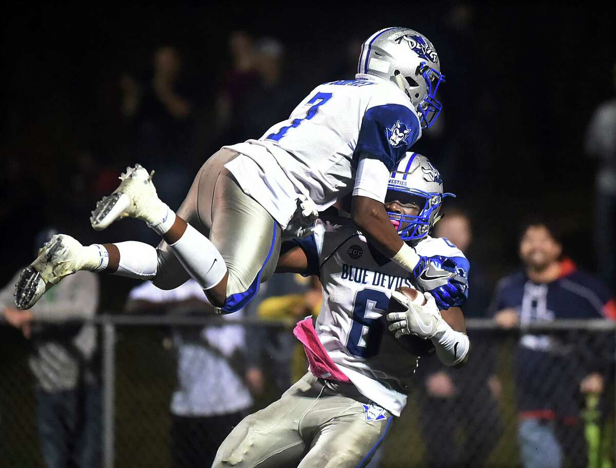 West Haven's Kyle Godfrey (7) celebrates with his brother Anthony Godfrey (6) after Anthony's 78 yard run for a touchdown in the third quarter defeating Notre Dame (WH), 36-13, Friday night, October 21, 2016, at Veterans Memorial Field in West Haven. (Catherine Avalone/New Haven Register)