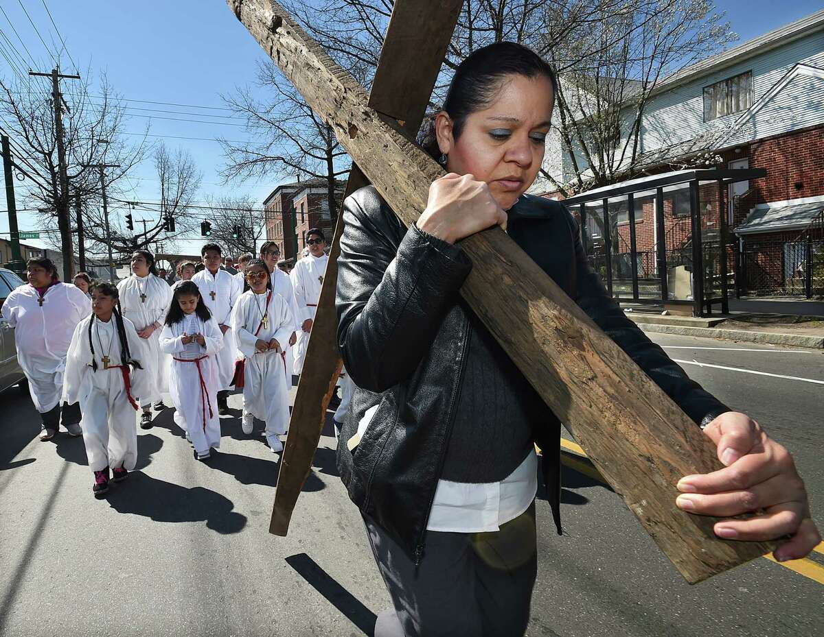 Angelina Malpica bears the smaller of two crosses carried by parishoners of St. Rose of Lima Church on Good Friday, April 14, 2017, for the Via Crucis - Way of the Cross procession through out the streets of Fair Haven.
