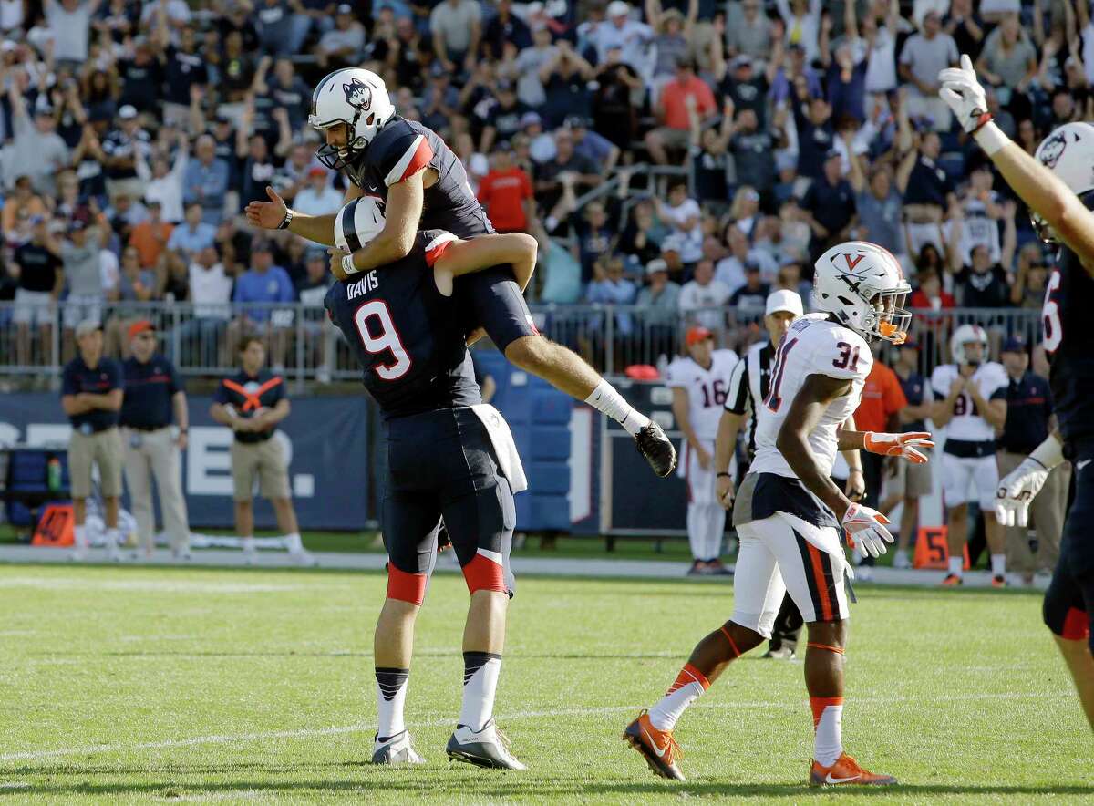 Connecticut placekicker Bobby Puyol, top, celebrates his game-winning field goal with Tyler Davis (9) beside Virginia's Kareem Gibson (31) in the second half of an NCAA college football game at Pratt & Whitney Stadium at Rentschler Field, Saturday, Sept. 17, 2016, in East Hartford, Conn. Connecticut won 13-10.