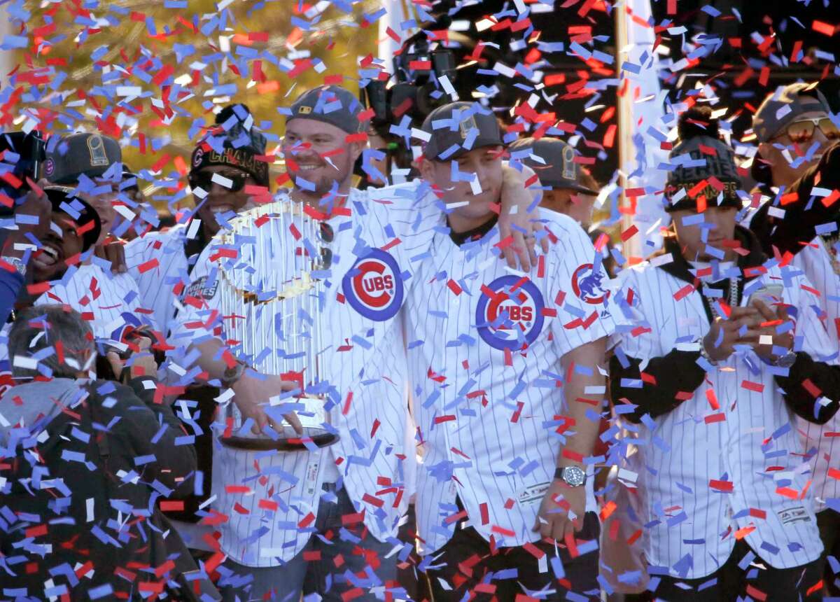 Chicago Cubs John Lester, left, holds the Commissioner's Trophy while he and Anthony Rizzo celebrate during a rally in Grant Park honoring the World Series baseball champions Friday, Nov. 4, 2016, in Chicago.