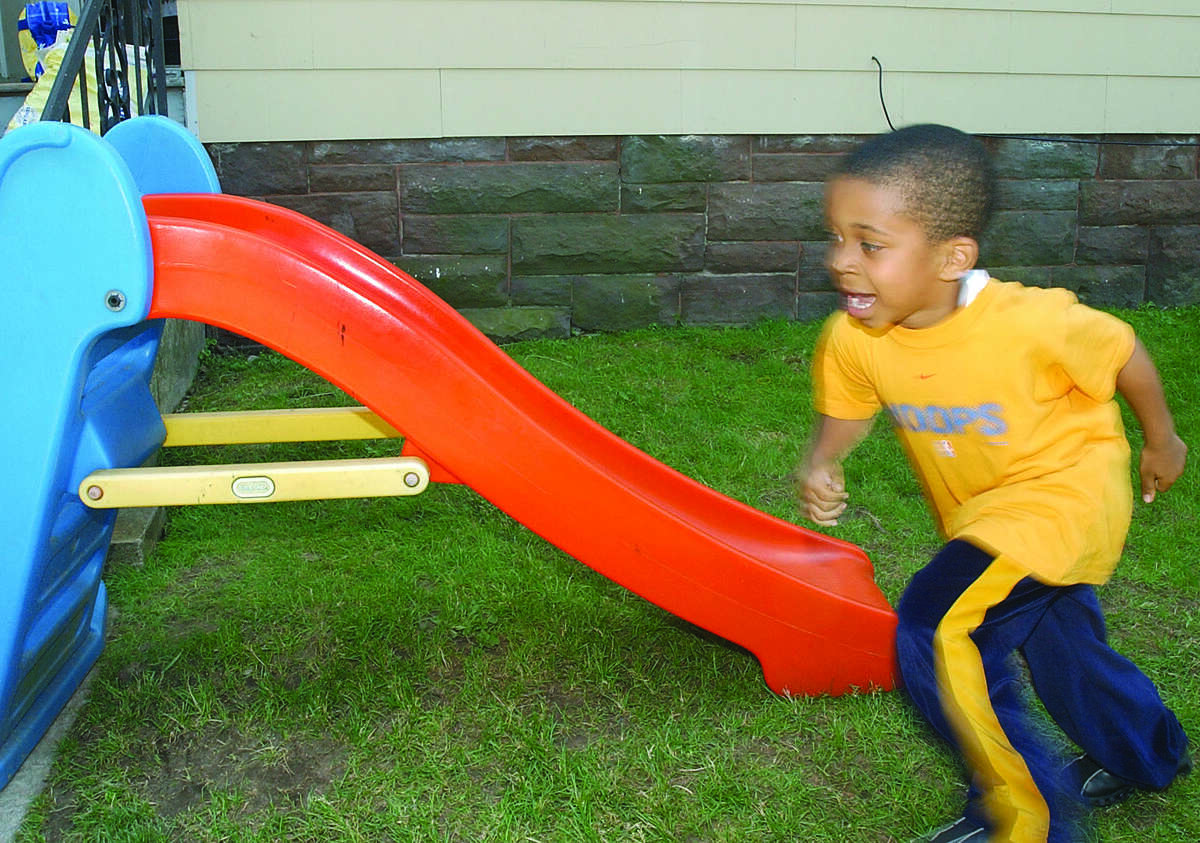 Trevon James, 4, of Middletown, runs around to the stairs of the slide so he can go down again in a yard on Spring St. in Middletown Tuesday.....photo by Irena Pastorello...061703...web;MPagai.jpg