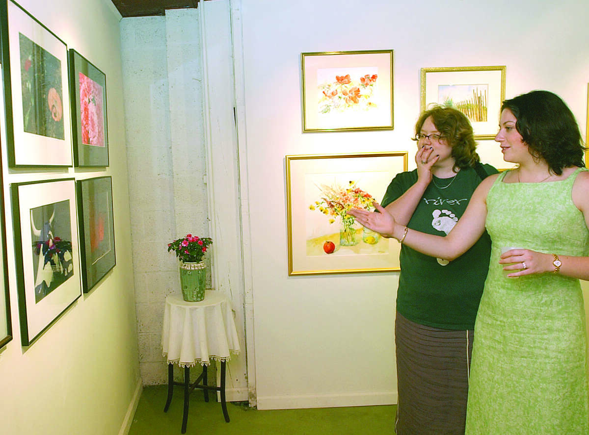 Elizabeth Kreamer (right) of Norwalk, answers questions about her artwork posed by Stephanie Ratcliffe of Bridgeport during the opening reception for a group show of artwork and photography at The Gallery at Riverside Press in Essex on Sunday....photo by Irena Pastorello....060803....web:MPansw.jpg