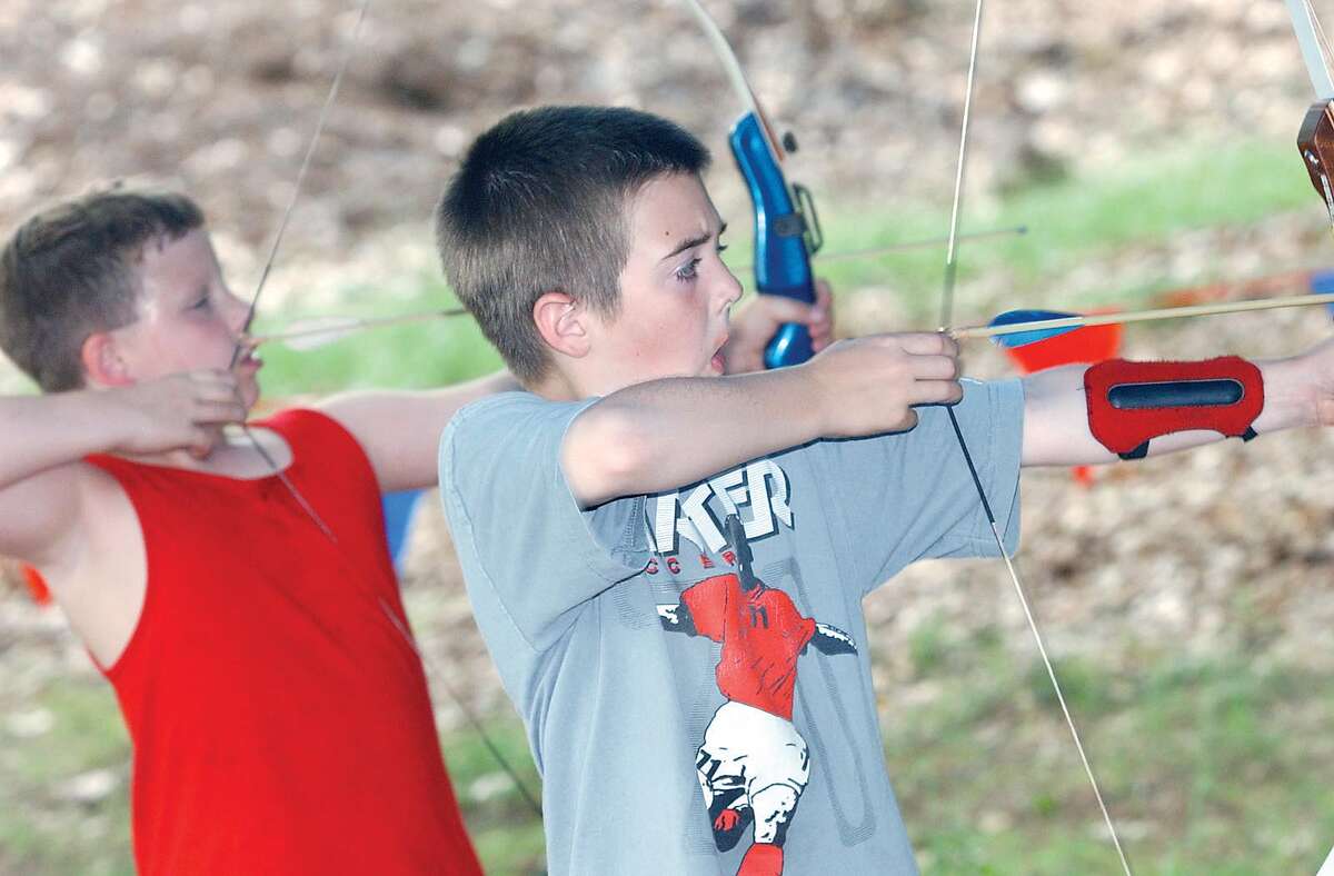 Brandon Downer and Jeremy Tetrault, both 9 and from Middletown, take aim with their bows and arrows during the Middletown Cub Scout Day Camp in Middletown on Friday at the Falcoln Pavillion at Crytstal Lake..............TW photo...........071803.