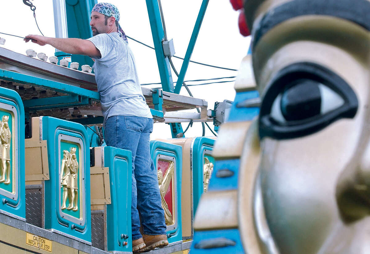 Frank Rizzo works on the assembly of Pharoh's Fury, a carnival ride, Tuesday at the fairgrounds of the Durham Fair. The fair opens this weekend.....J. Rossi photo....092303.