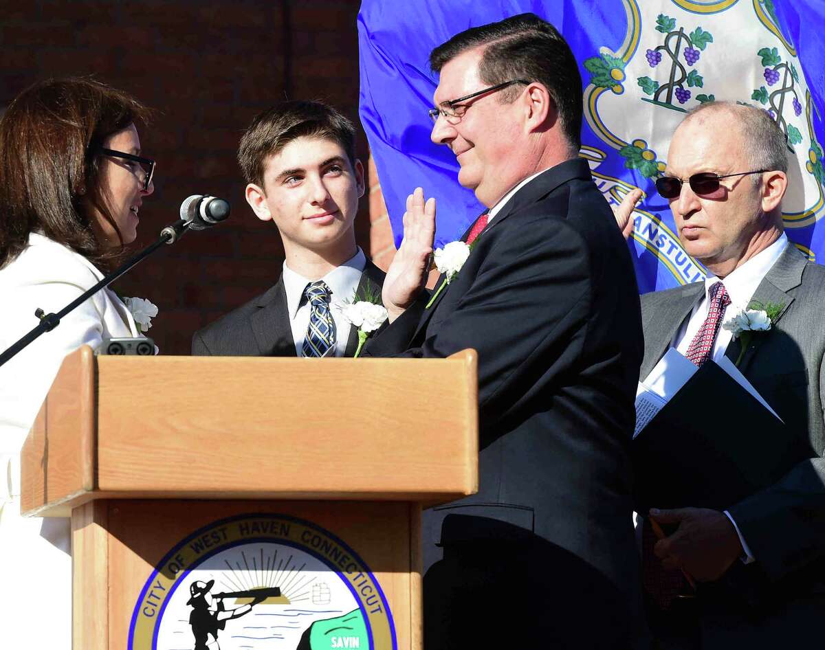 (Peter Hvizdak - New Haven Register) State Senator Gayle Slossberg, left, swears in West Haven Mayor Edward M. O'Brien during his inauguration Sunday, December 6, 2015 in front of West Haven City Hall as O'Brien's son David O'Brien, second from left, and Master of Ceremony Vincent N. Amendola, Jr. Esq, far right, watch.