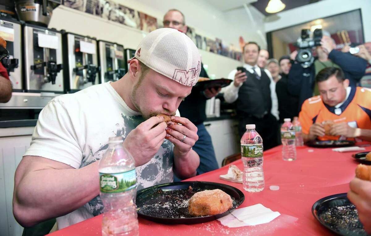 Nick Wehry (center) of Torrington competes in the 18th annual Paczki Eating Contest at Eddy's Bake Shop in Ansonia on 2/9/2016. Photo by Arnold Gold/New Haven Register agold@newhavenregister.com