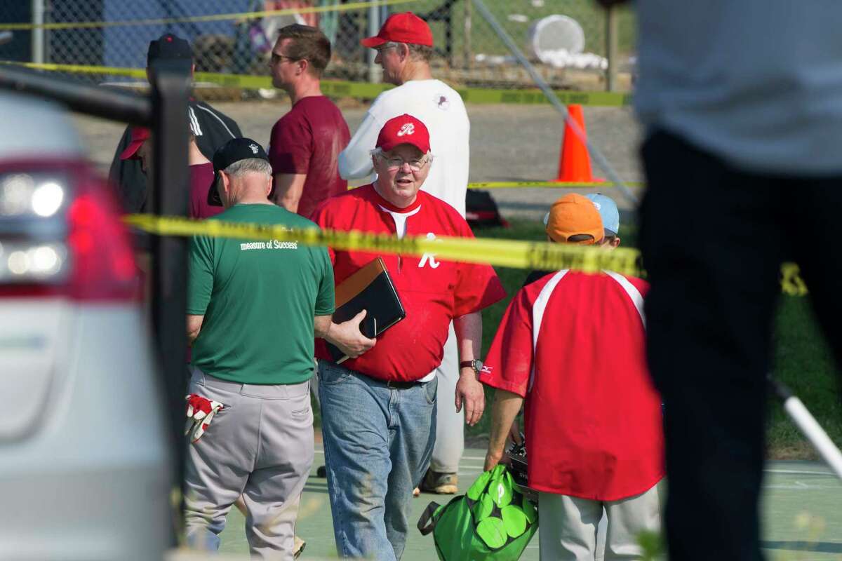 Rep. Joe Barton, R-Texas, center, and other members of the Republican Congressional softball team, stand behind police tape of the scene of a multiple shooting in Alexandria, Va., Wednesday, June 14, 2017, where House Majority Whip Steve Scalise of La. was shot.