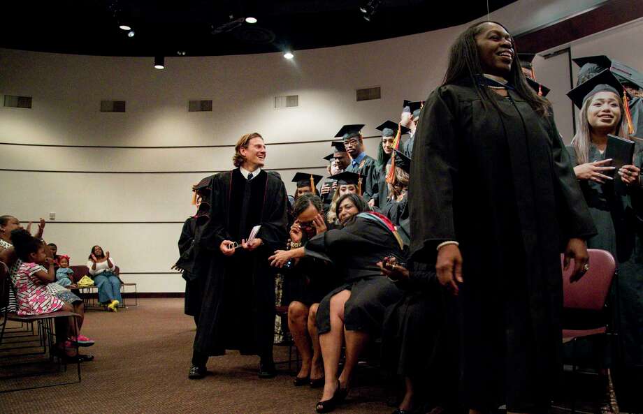 Matthew Russell, center, smiles after a graduation ceremony for Middle College High School. He was the spring 2017 commencement speaker, after building a relationship with staff and students through his Iconoclast poetry program. Photo: Jon Shapley, Houston Chronicle / © 2017 Houston Chronicle