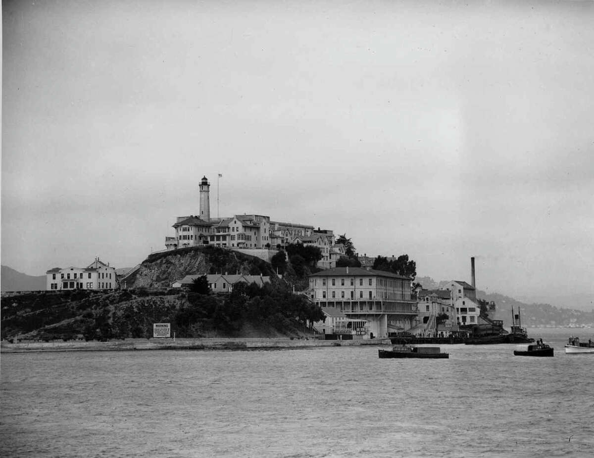 Three armored railroad cars arrive on a car ferry at the United States Penitentiary on Alcatraz Island, San Francisco, Calif., on August 22, 1934. Under the watchful eyes of guards carrying rifles, the prisoners, among them former Chicago gang leader Al Capone, leave the coaches for transfer to the cell house. (AP Photo)