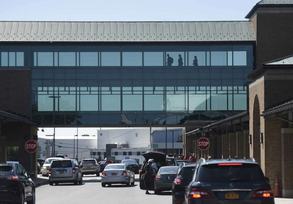Above, passengers enter and exit the terminal at Westchester County Airport. Below, passengers check in to a United flight.