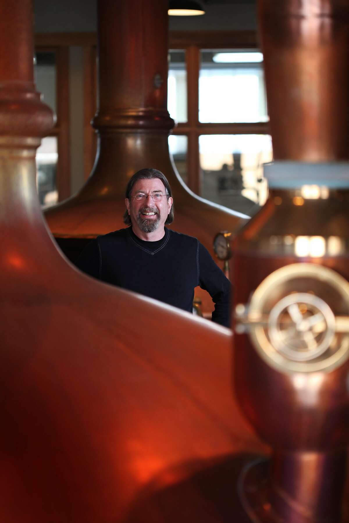 2013年3月5日，加州旧金山，Anchor Brewers & Distillers的总裁兼首席执行官Keith gregggor在该公司的波特雷罗山总部的酿造壶中摆姿势拍照。