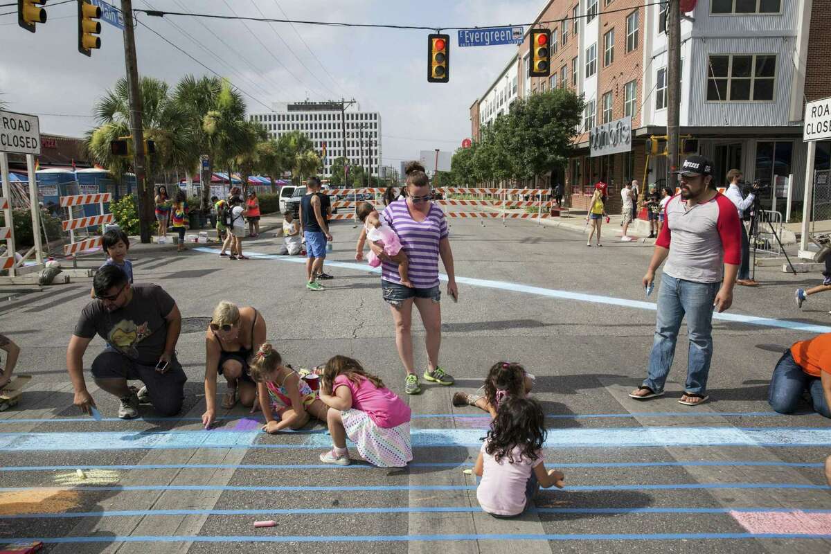 Volunteers use chalk to create rainbow crosswalks in honor of this year’s LGBTQ pride celebration.