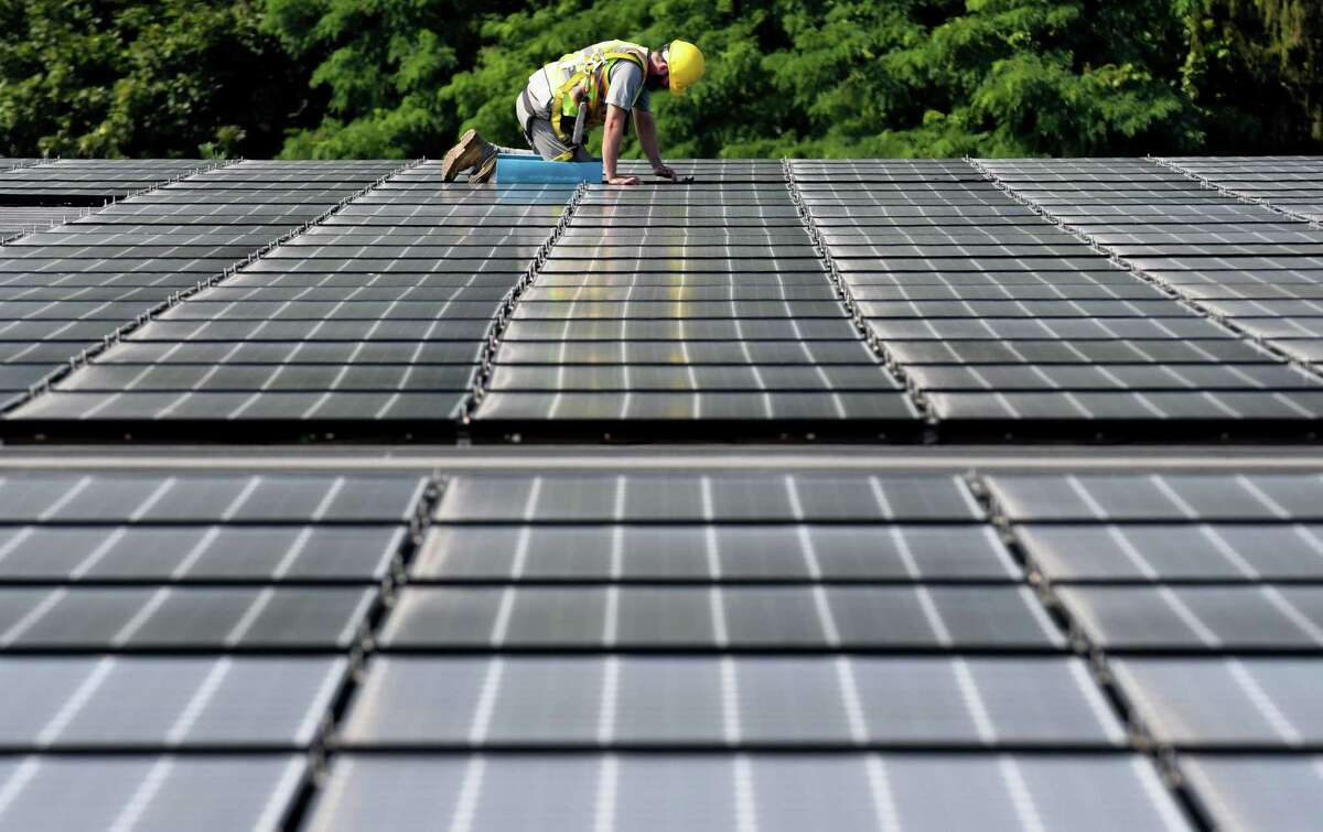 Panels for a solar array are installed on the roof of Dimension Fabricators on Thursday, Aug. 3, 2017, in Glenville, N.Y. (Will Waldron/Times Union)