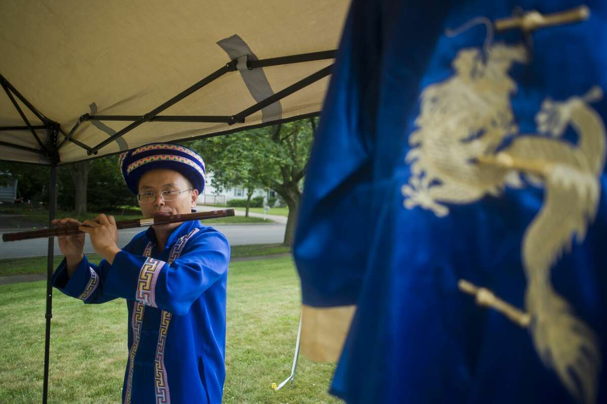 Joe Chai plays a traditional Chinese flute during First Baptist Church's neighborhood block party on Wednesday, August 2, 2017.