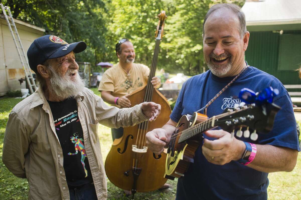 William Smith of Edenville, left, chats with Tom Galbraith of Ohio, right, and Gil Evans of Ohio, center, as they rehearse before performing with the rest of the Fossil Creek Band during the Salt River Bluegrass Festival on Friday, July 28 in Oil City.
