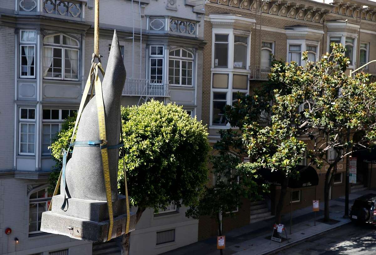 A crane lowers a penguin sculpture by artist Beniamino Bufano from its perch above Pine and Powell streets where it was installed in the back corner of the Stanford Court Hotel in San Francisco, Calif. on Saturday, July 22, 2017. The penguin will be restored and reinstalled at the main entrance of the hotel, which is undergoing a renovation, on California Street.