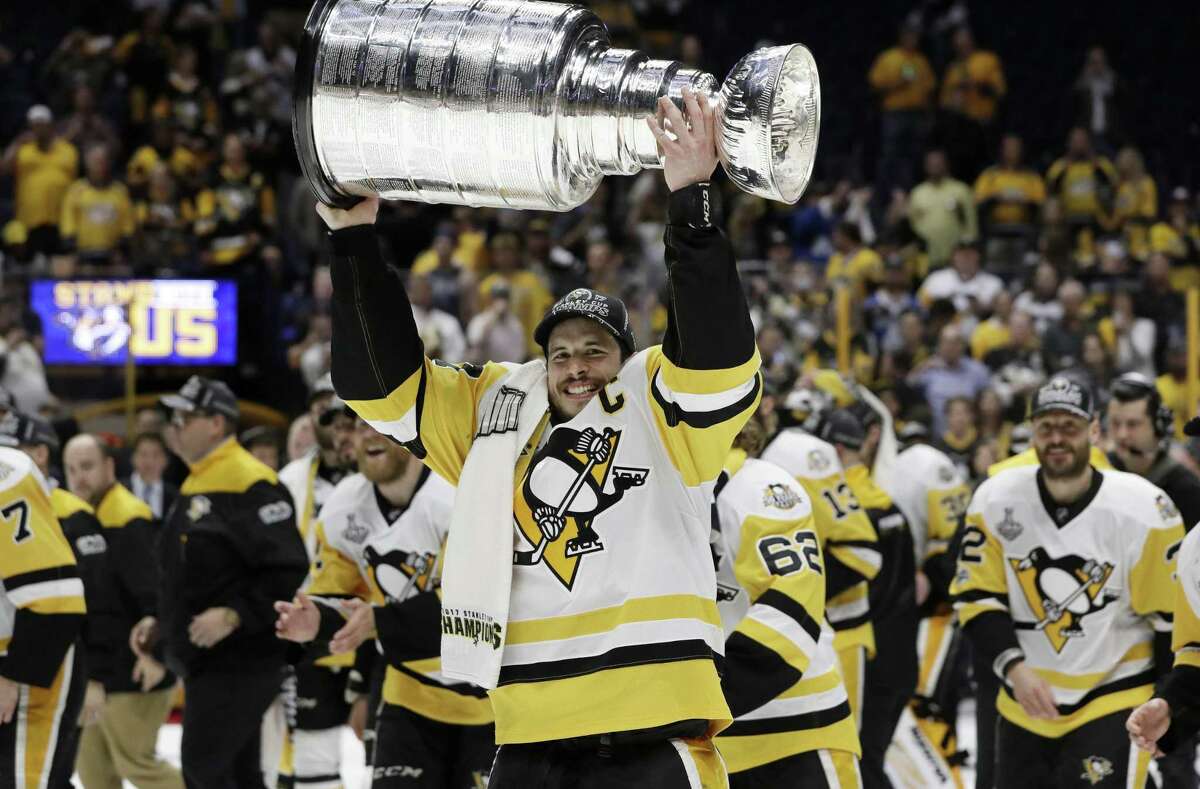 Pittsburgh Penguins captain Sidney Crosby carries the Stanley Cup after the Penguins defeated the Nashville Predators 2-0 in Game 6 of the NHL hockey Stanley Cup Finals Sunday, June 11, 2017, in Nashville, Tenn. The Penguins will face the St. Louis Blues Oct. 4, in the 2017-18 season opener, which will be shown on NBC Sports.