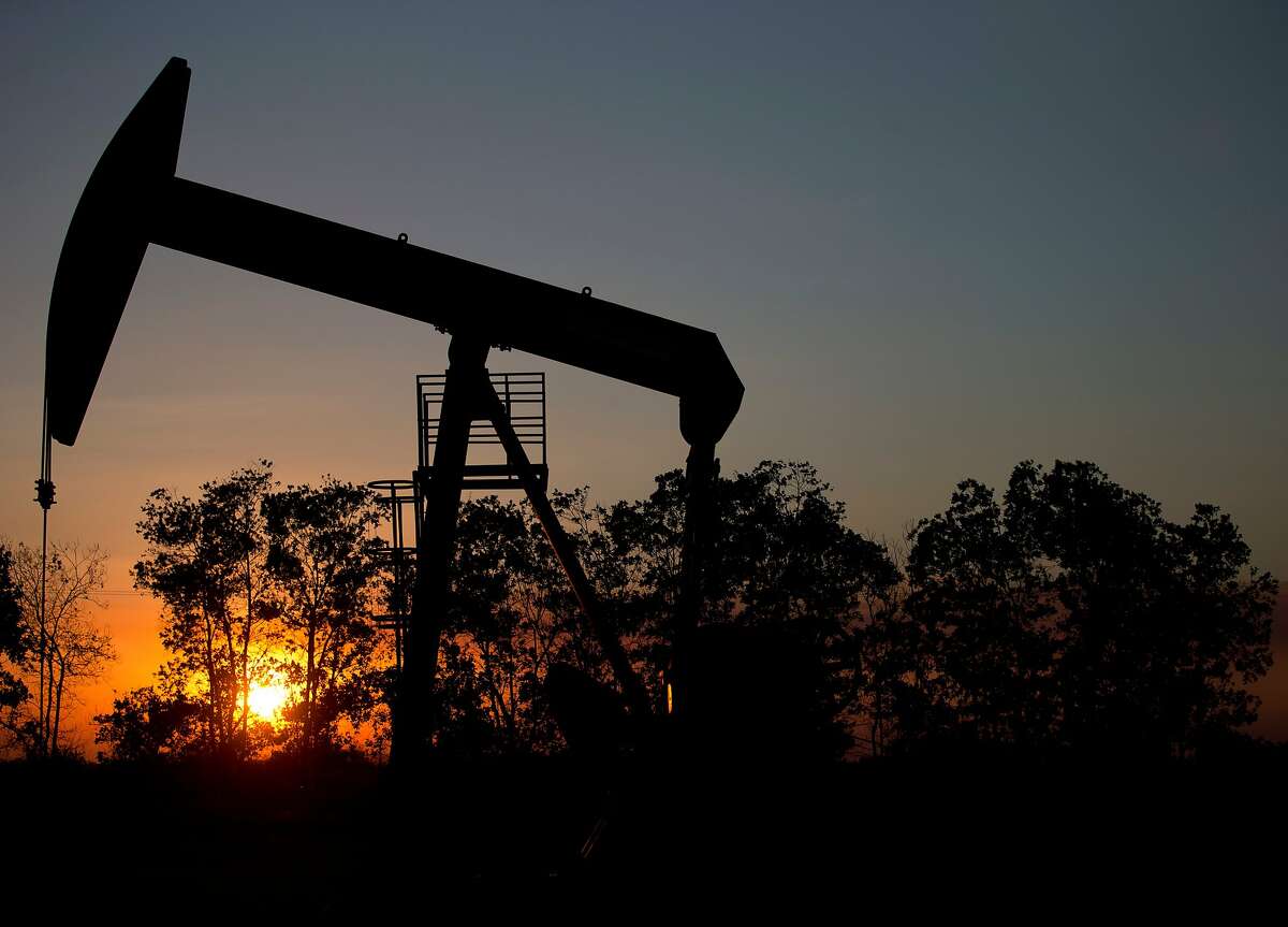 In this Feb. 19, 2015 photo, the sun sets behind an oil well in a field near El Tigre, a town within Venezuela's Hugo Chavez oil belt, formally known as the Orinoco Belt.