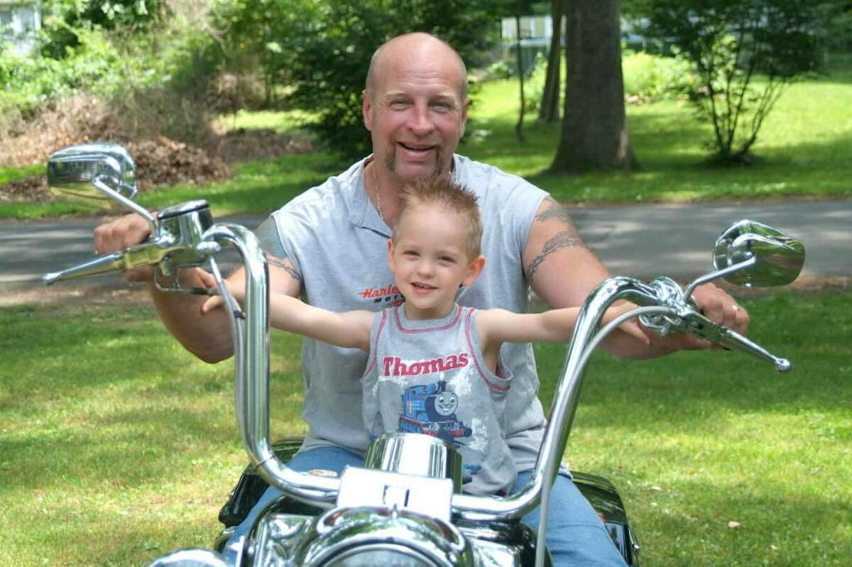 Kenny Ballard, of Sandy Hook, and his son, Kenny, 3, have some fun sitting on Dad's motorcycle. Dad is a milkman for Marcus Dairy in Danbury.