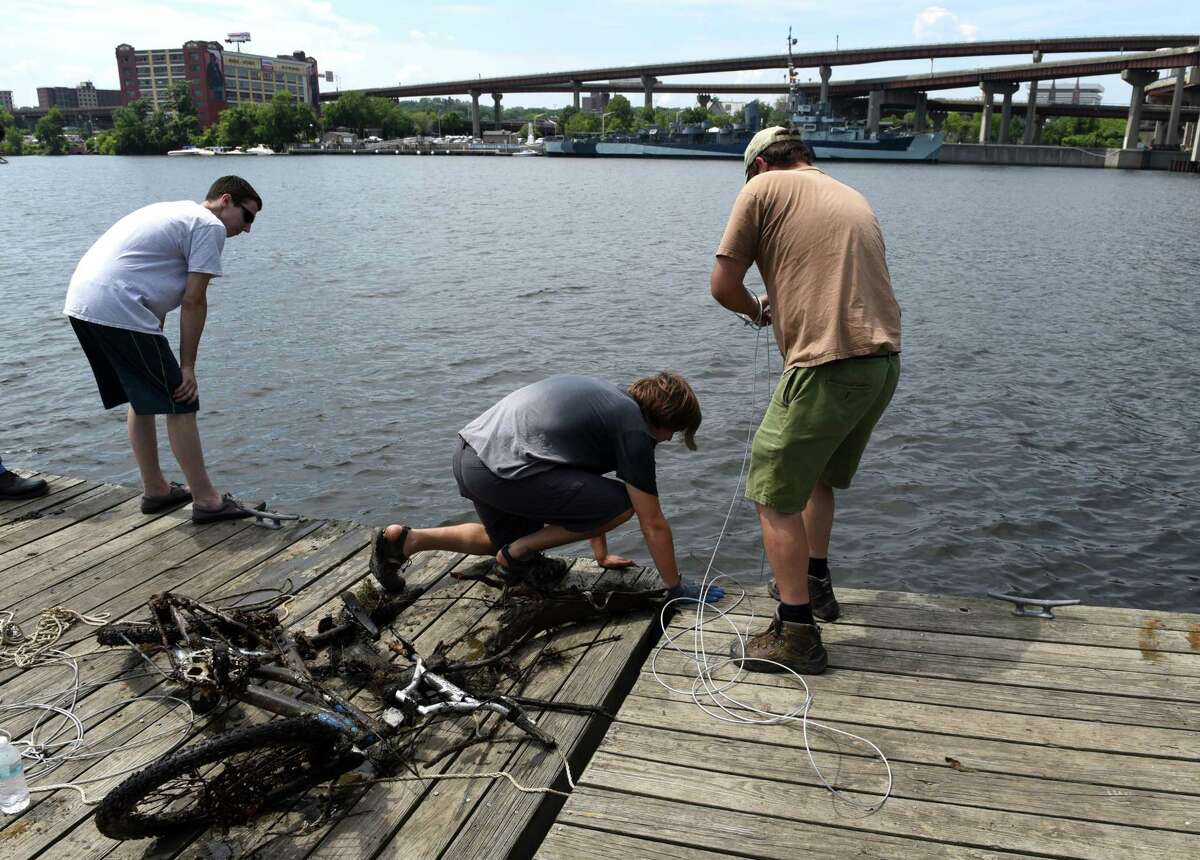 Dave Stacey of Coeymans, right, and his son, Druhan, center, haul ferrous treasures from the Hudson River as they magnet fish at Riverfront Park on Thursday, Aug. 3, 2017, in Rensselaer, N.Y. Powerful magnets attached to cables are dropped into the river to see what they can haul out. (Will Waldron/Times Union)