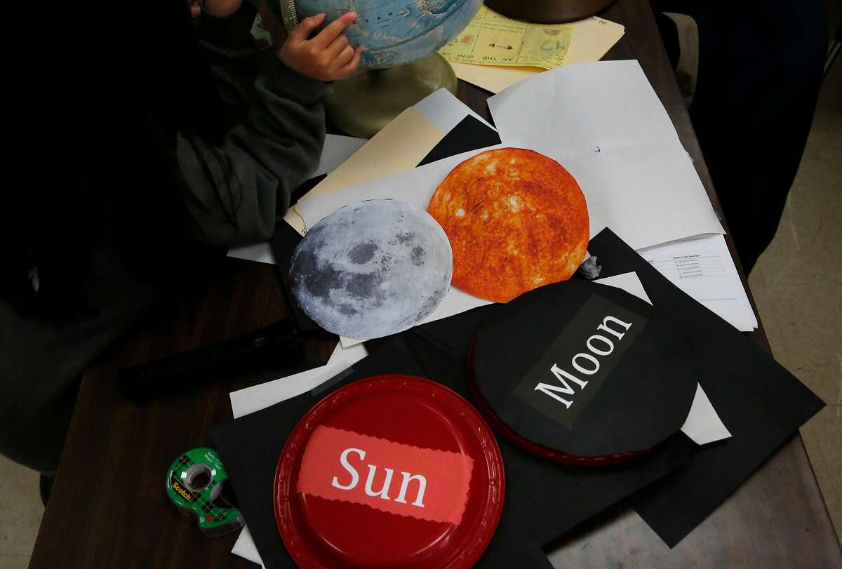 Saya Tarm, 9, checks out a globe with friends as pictures of the sun and moon lay next to her on the table leftover from the solar eclipse lesson during a SummerGATE class at St. Anne's campus August 3, 2017 in San Francisco, Calif. The class not only learned about how the solar eclipse happens, but they also learned how to create a pinhole viewing apparatus for safe viewing.